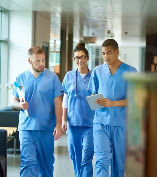 Một người đeo găng tay y tế màu xanh đang dùng một miếng vải lau màu vàng để lau chùi một bề mặt kim loại có độ phản chiếu cao, trong một không gian dường như là cơ sở y tế hoặc phòng thí nghiệm, với các thiết bị khoa học mờ ảo ở phía sau.